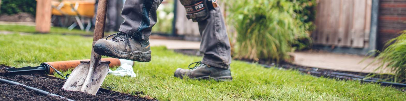 Aanleghovenier van Janse & Berkhof Tuinen is bezig met de beplanting van een tuin