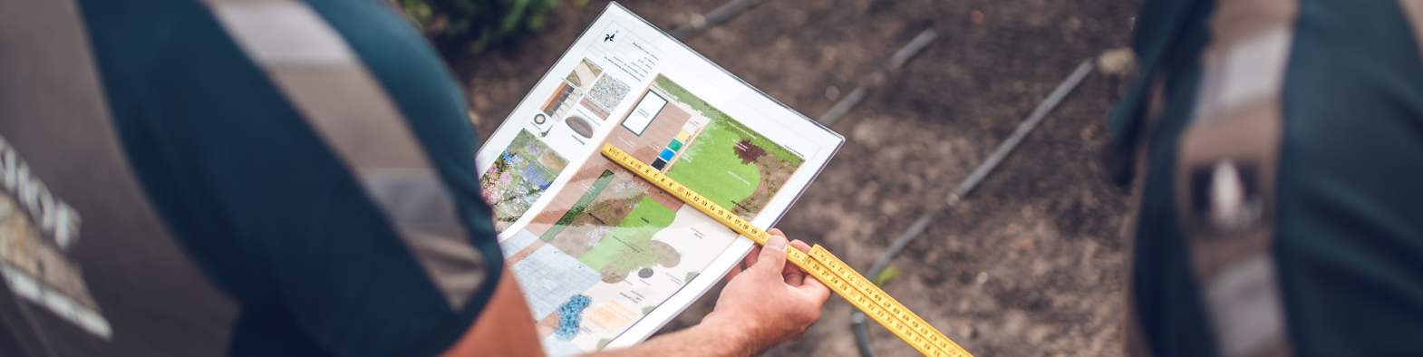 Een aanleghovenier van is bezig met de vlakverdeling en hoogte op basis van een tuinontwerp van Janse & Berkhof Tuinen